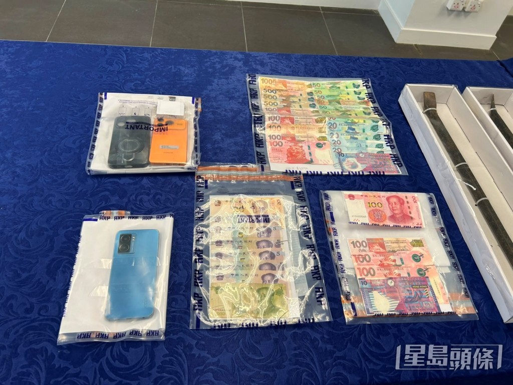 警方在疑犯電話及一批現金。 警方在疑犯電話及一批現金。