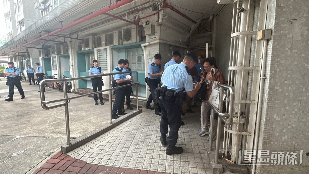 警察機動部隊在大廈出入口向居民登記並詢問是否住5號或7號室。
