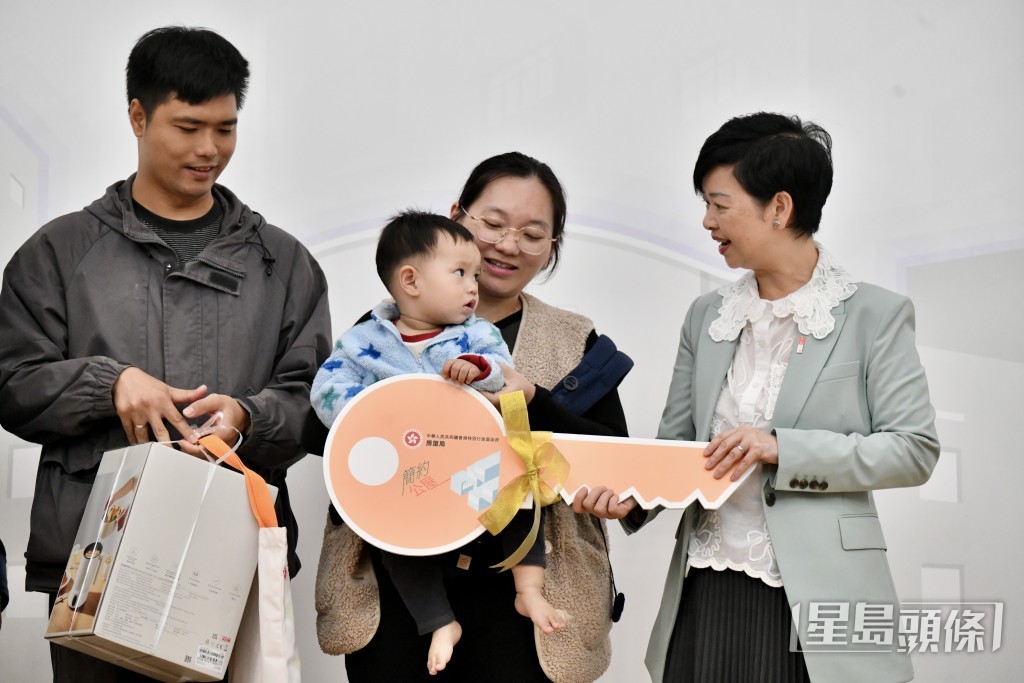 何永贤向三户入住家庭送上电热水壶。