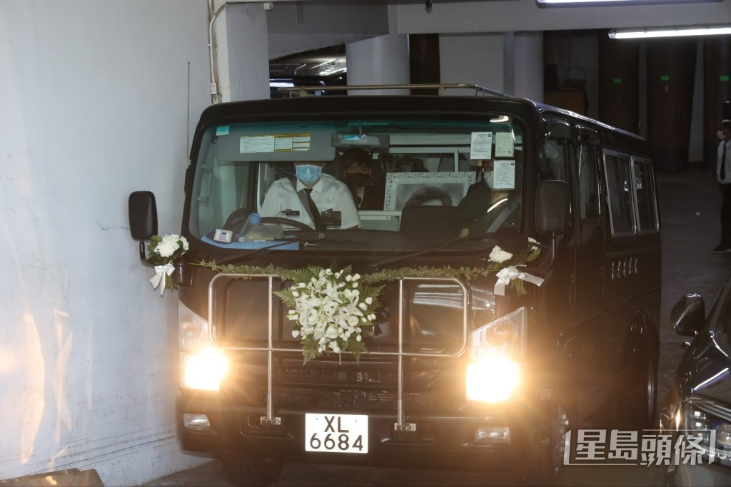樂易玲的大仔捧著爸爸遺照登上靈車。 樂易玲的大仔捧著爸爸遺照登上靈車。