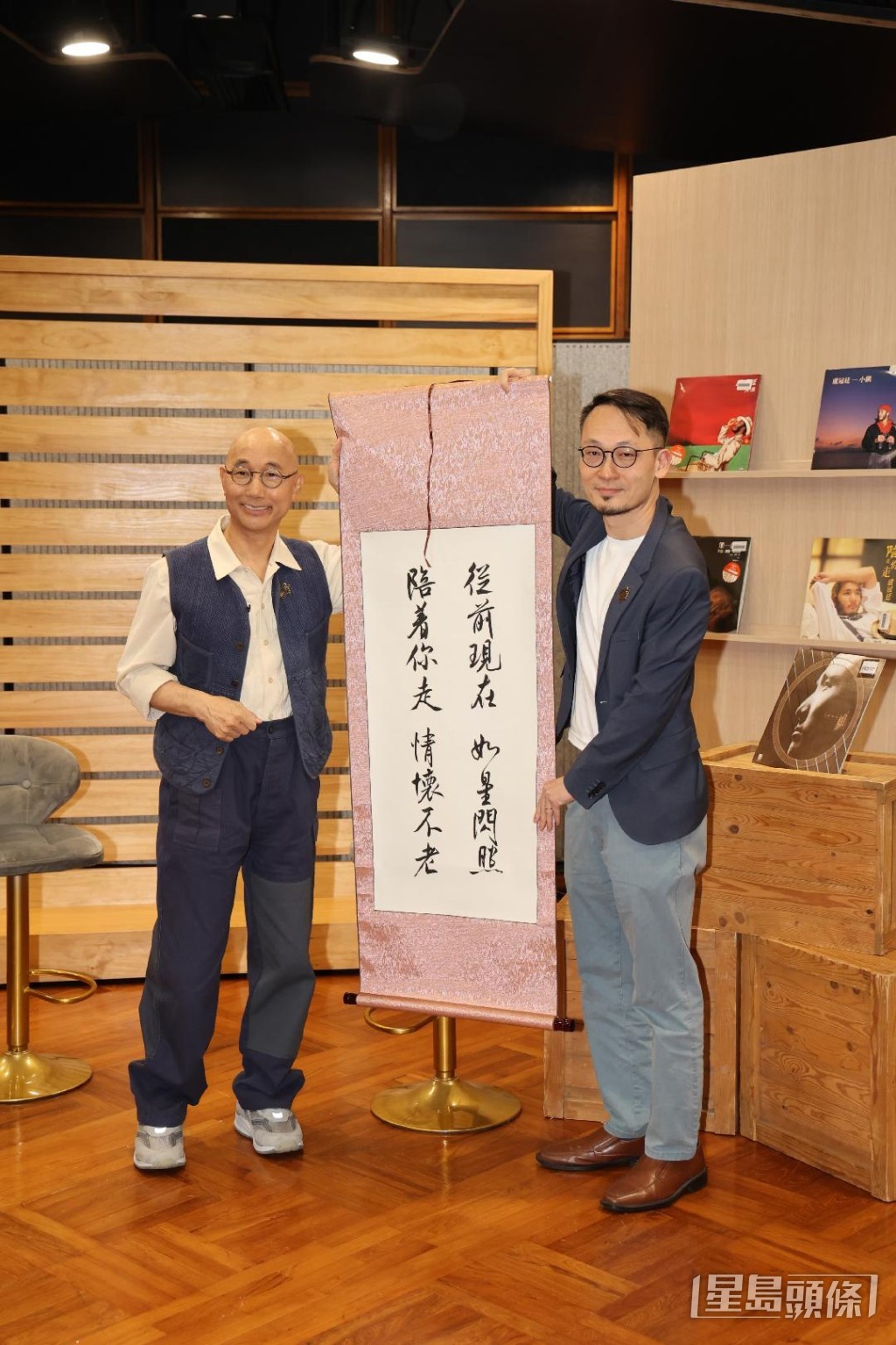 助理廣播處長（電台及節目策劃）葉冠霖向盧冠廷送上書法卷軸致賀。