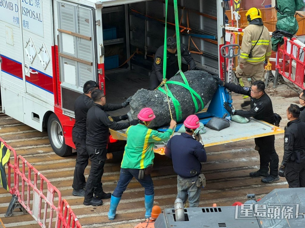 工人將巨石吊起，並放入EOD車輛內運走。