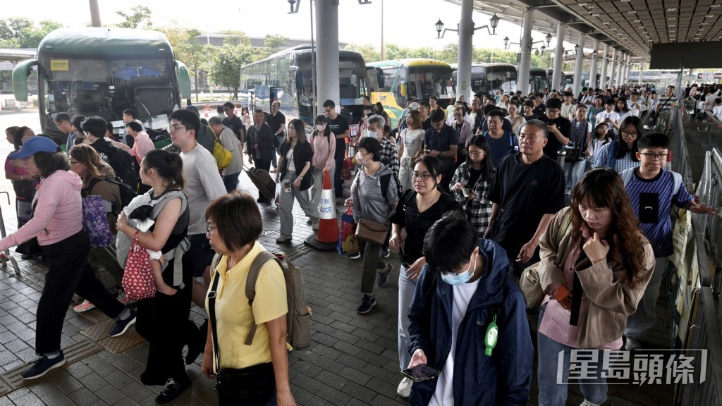 大批旅客排隊等候巴士出市區。