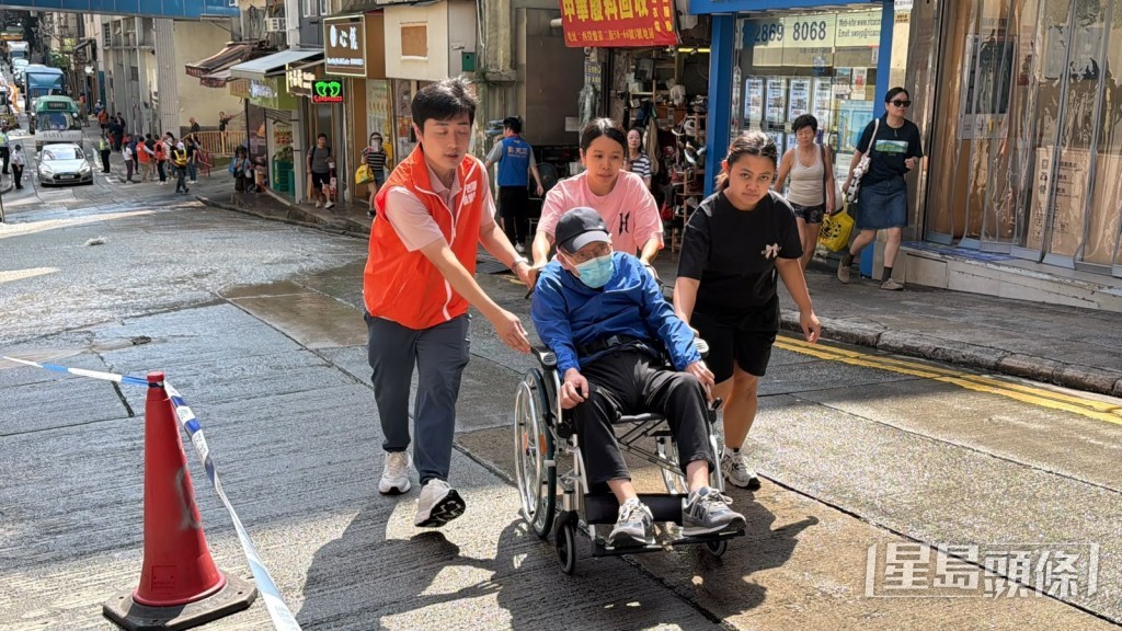 關愛隊到場協助長者輪椅出入。劉漢權攝