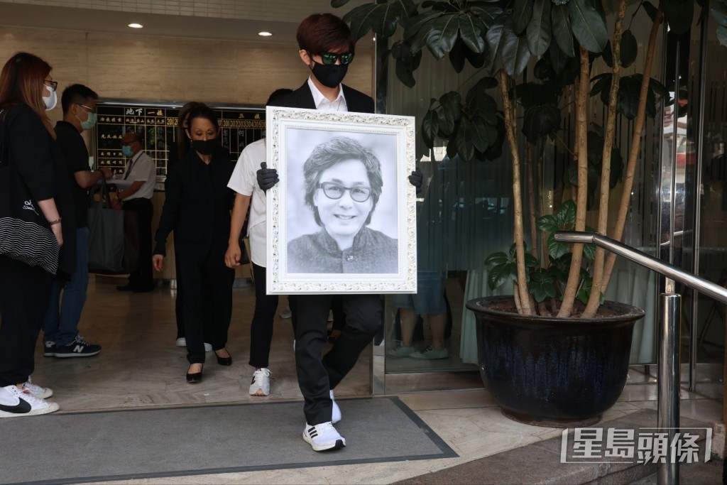 樂易玲的大仔捧著爸爸遺照登上靈車。 樂易玲的大仔捧著爸爸遺照登上靈車。