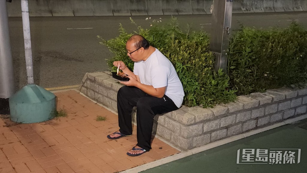 曾男手持入境處提供的飯盒,離開總部後即場開餐。黎志偉攝 曾男手持入境處提供的飯盒,離開總部後即場開餐。黎志偉攝