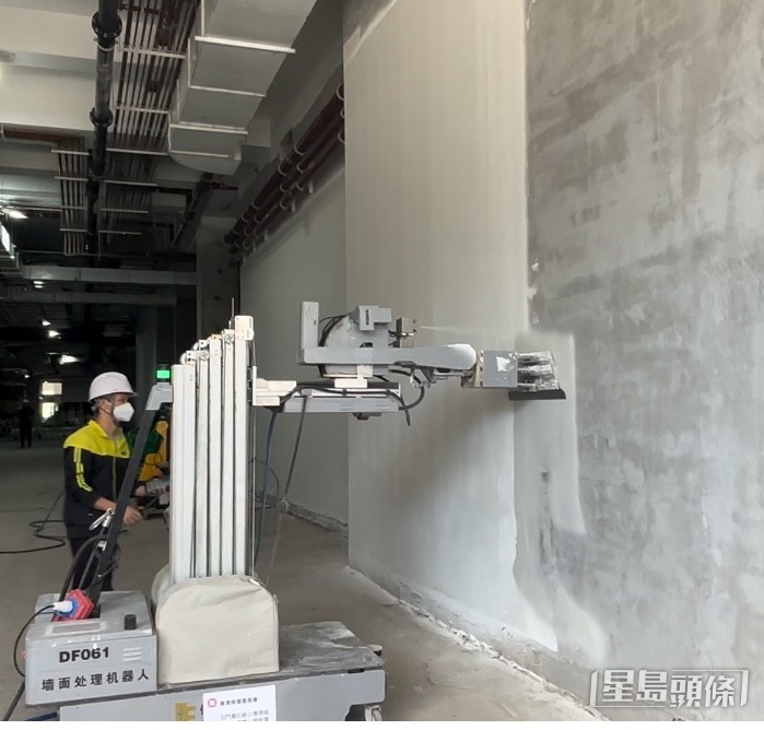 大型号机器人对墙面进行批荡，作业高度可达5至6米。郭颖彤摄