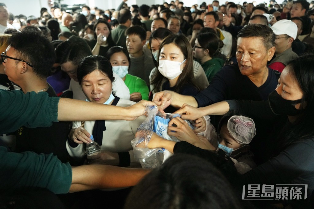 职员向排队人员派发樽装水。吴艳玲摄