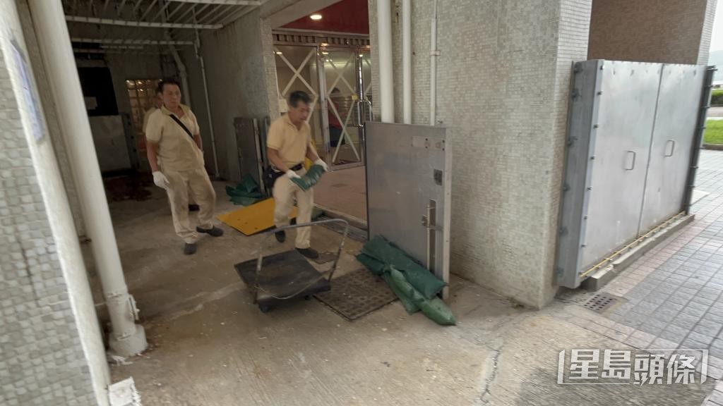 物管人員在颱風前於屋苑放置沙包擋水。 物管人員在颱風前於屋苑放置沙包擋水。