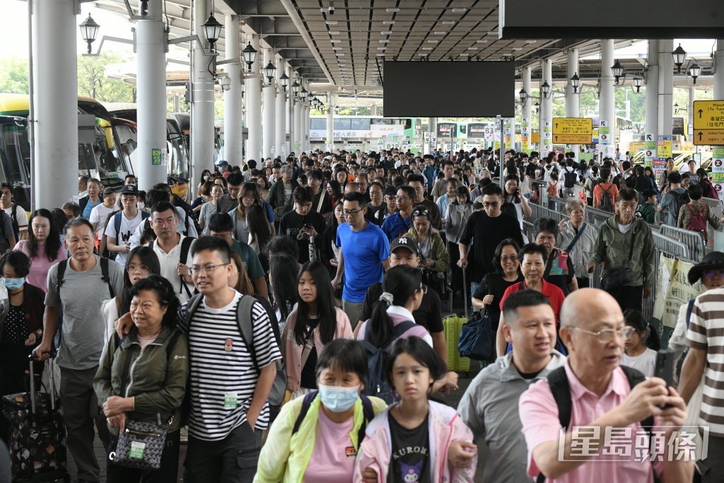 大批旅客排隊等候巴士出市區。