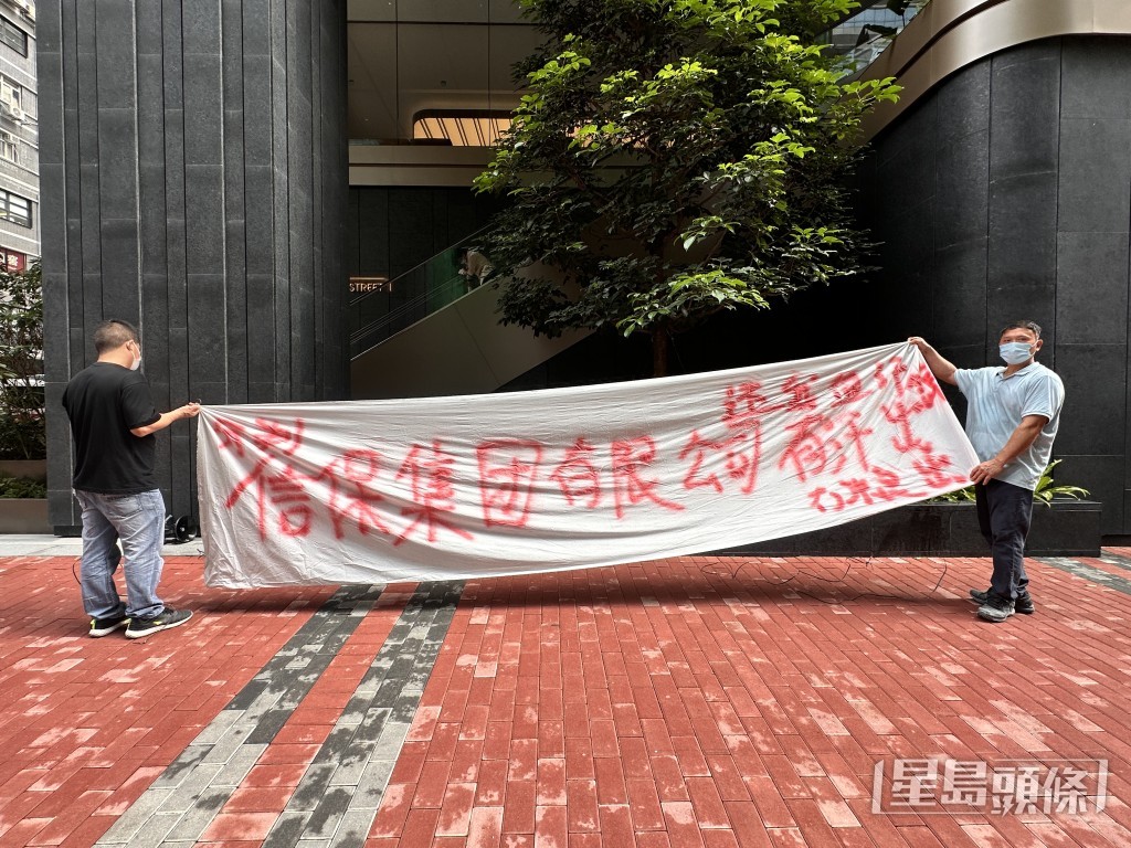 工人到商廈拉起橫額追薪。梁國峰攝 工人到商廈拉起橫額追薪。梁國峰攝