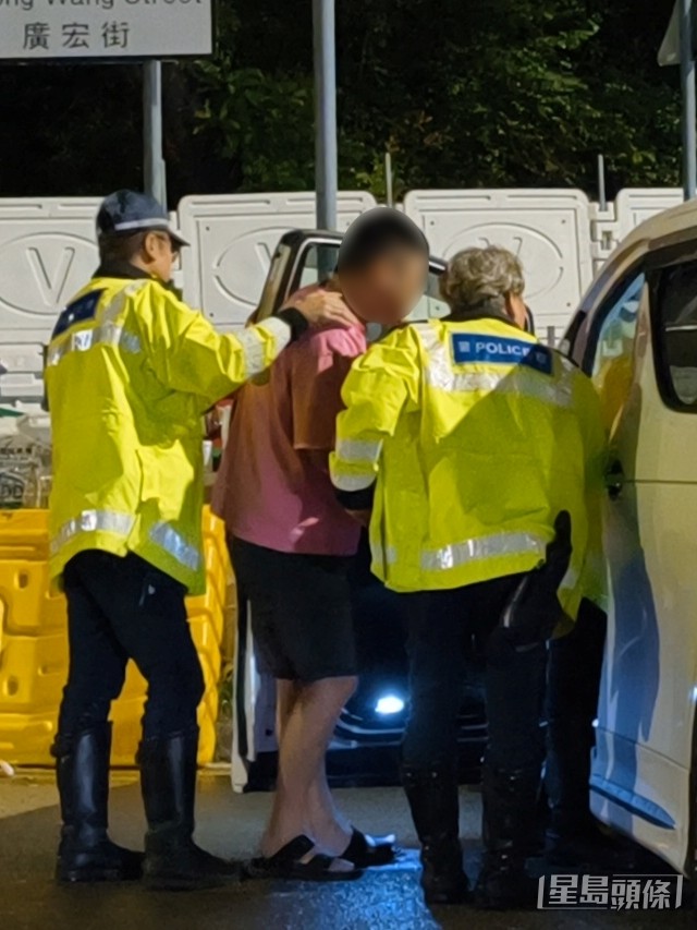 警员押解男司机至车辆搜查。 警员押解男司机至车辆搜查。