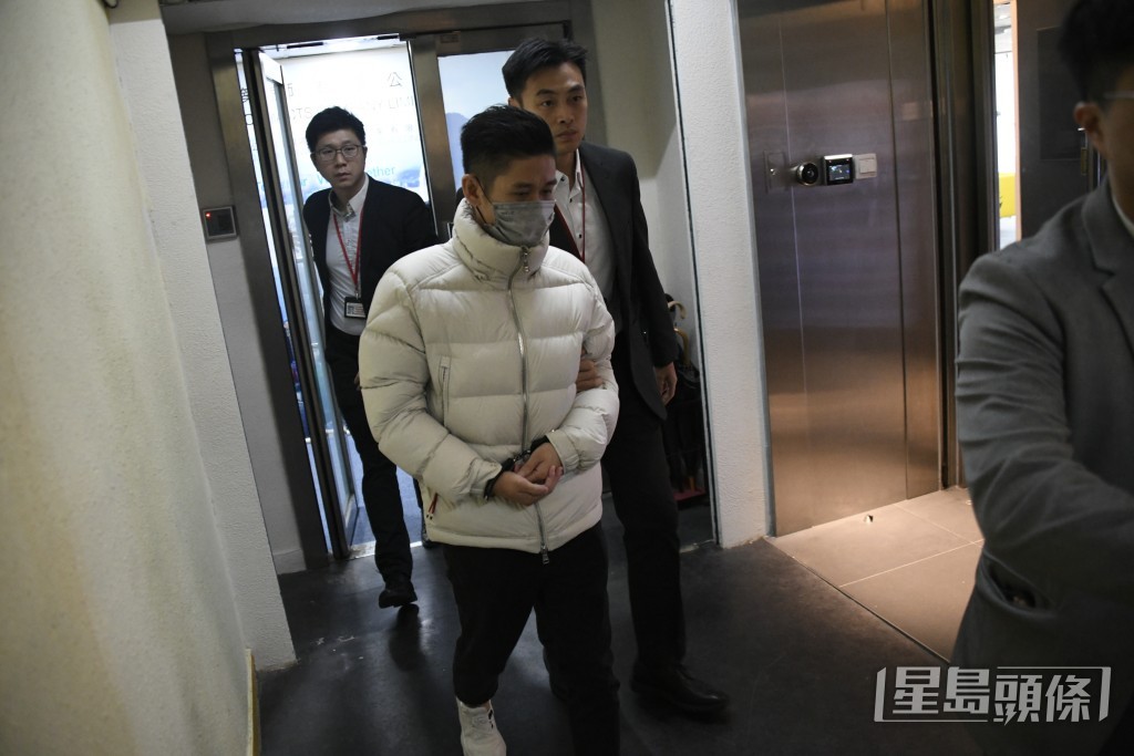 男子雙手被鎖上手銬。楊偉亨攝