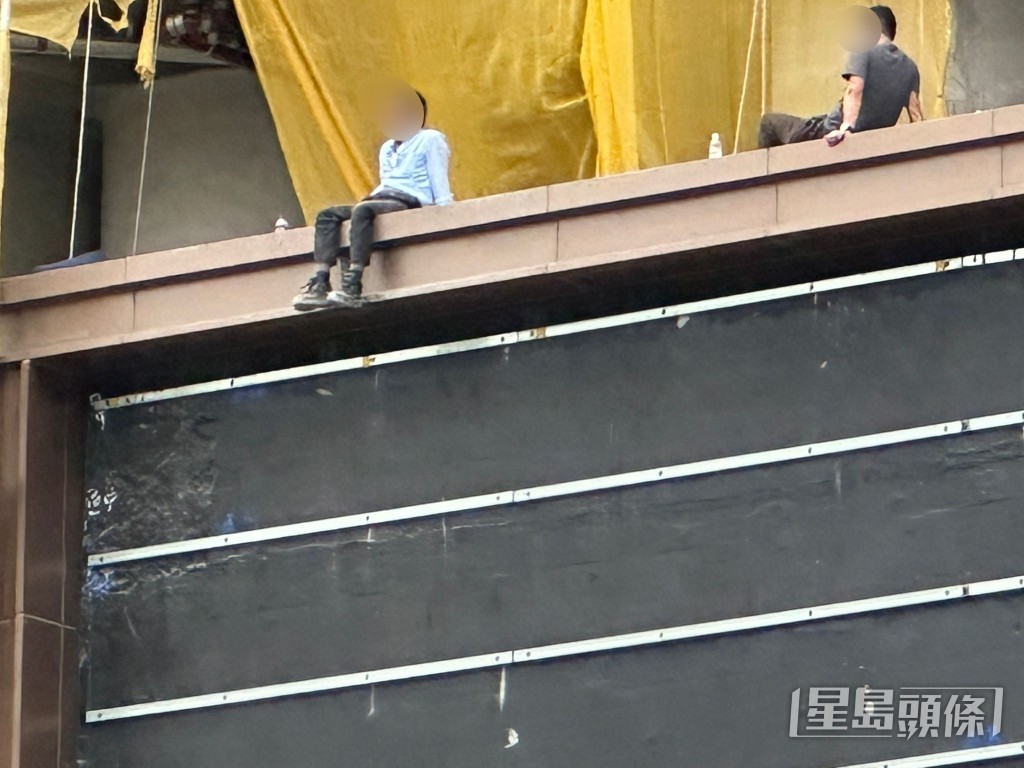 工人危坐五樓平台邊緣。 工人危坐五樓平台邊緣。