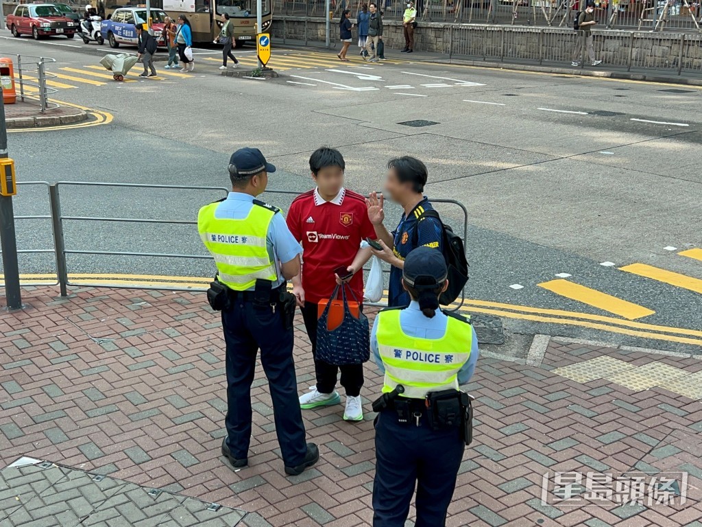 林先生见车流停止,遂偷步过路,被警员截停警告。 林先生见车流停止,遂偷步过路,被警员截停警告。