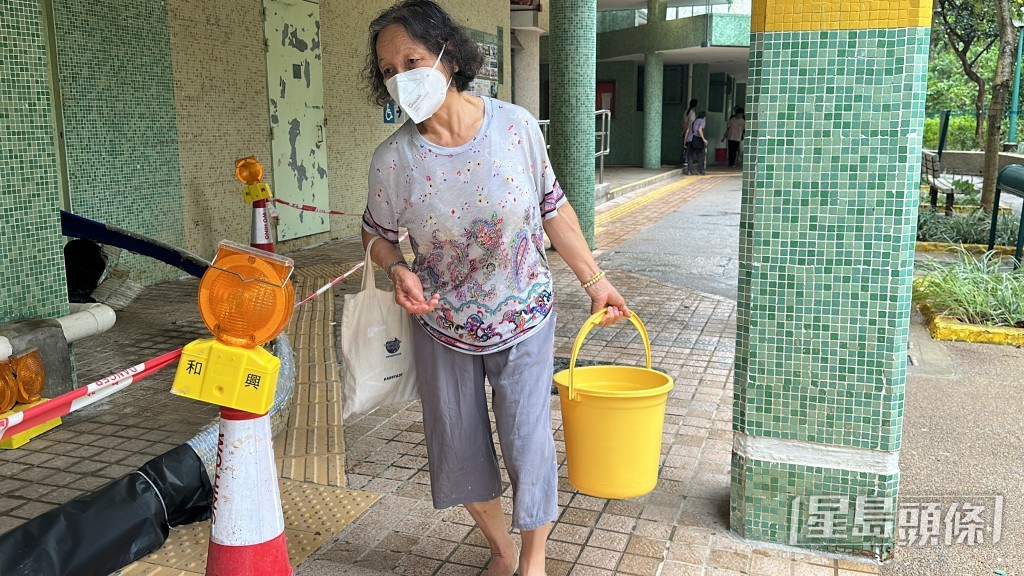 居民以大膠桶取水。