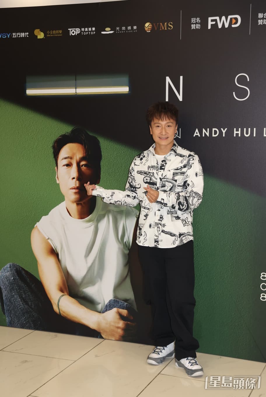 方力申在演唱會布景板前擺出鬼馬姿勢合照。