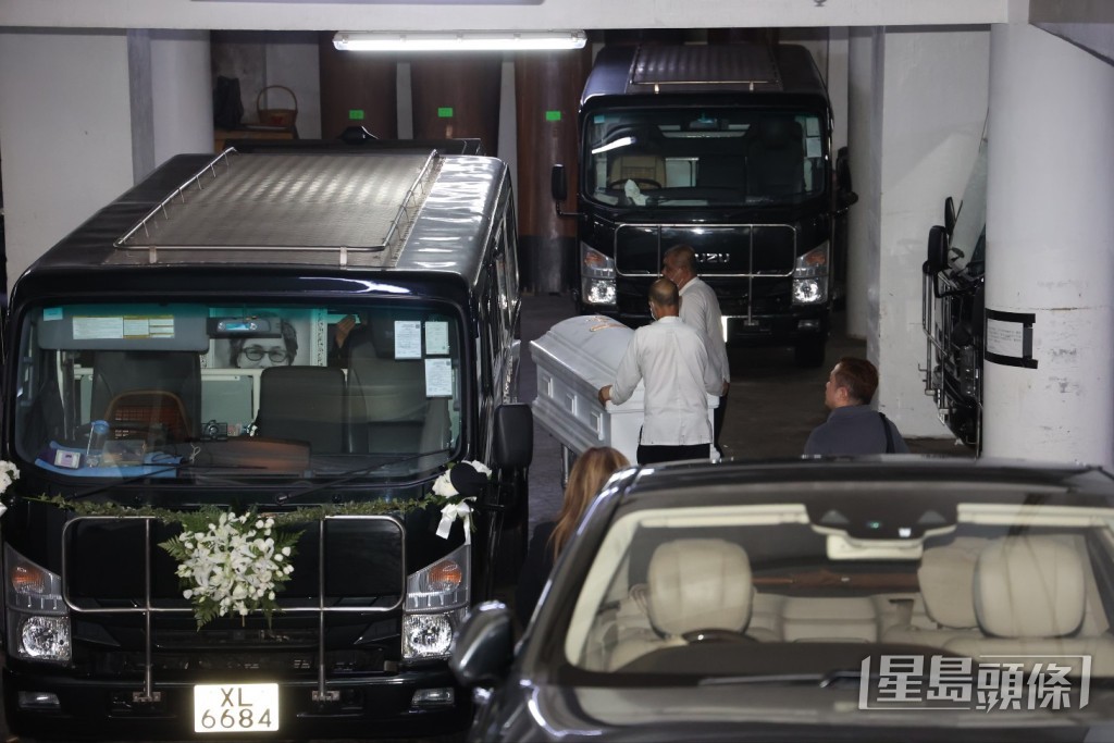 樂易玲的大仔捧著爸爸遺照登上靈車。 樂易玲的大仔捧著爸爸遺照登上靈車。