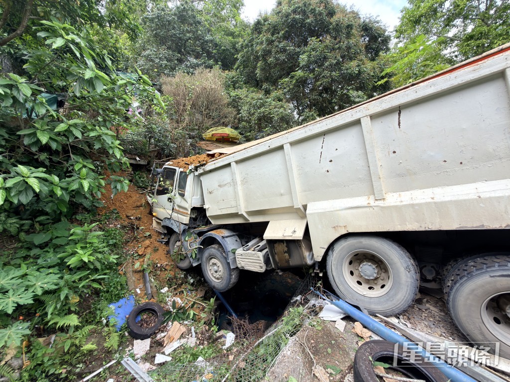 泥頭車卡在山坡與污水渠間。梁國峰攝 泥頭車卡在山坡與污水渠間。梁國峰攝