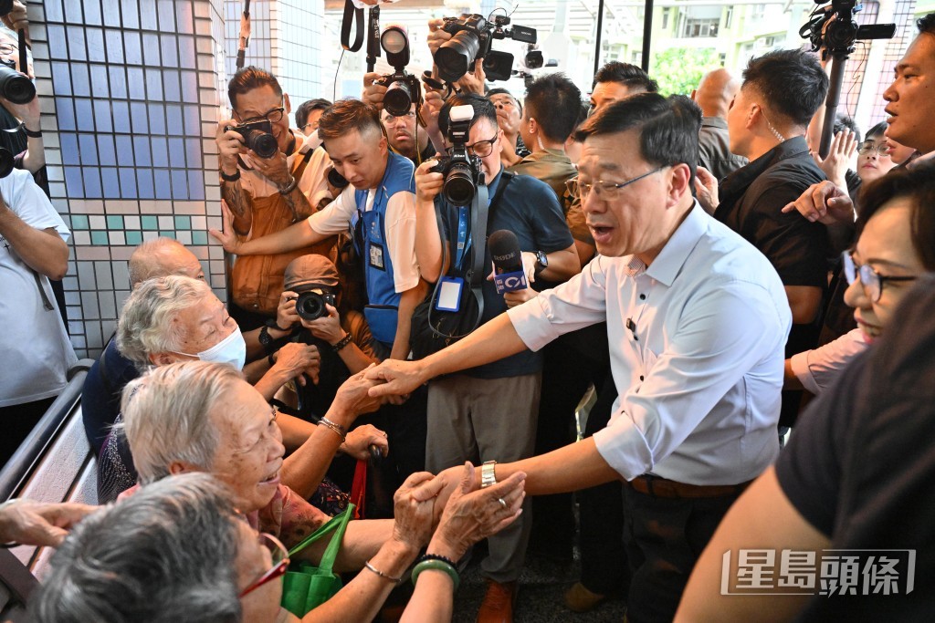 李家超又與數名由蘇屋邨搬遷至元州邨的長者聊天。 李家超又與數名由蘇屋邨搬遷至元州邨的長者聊天。