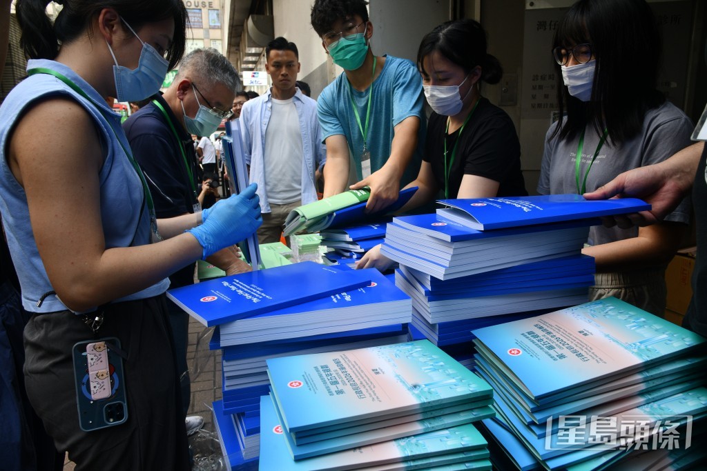 市民領取《香港第一個五年規劃》和《施政報告》。
