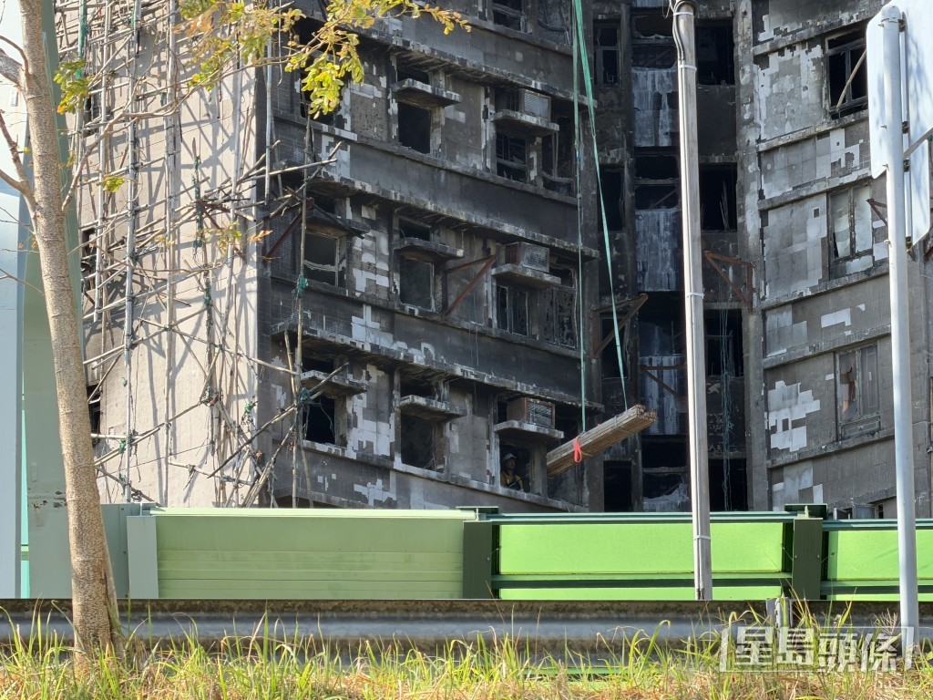 人員將鐵架經窗戶吊入單位。 人員將鐵架經窗戶吊入單位。