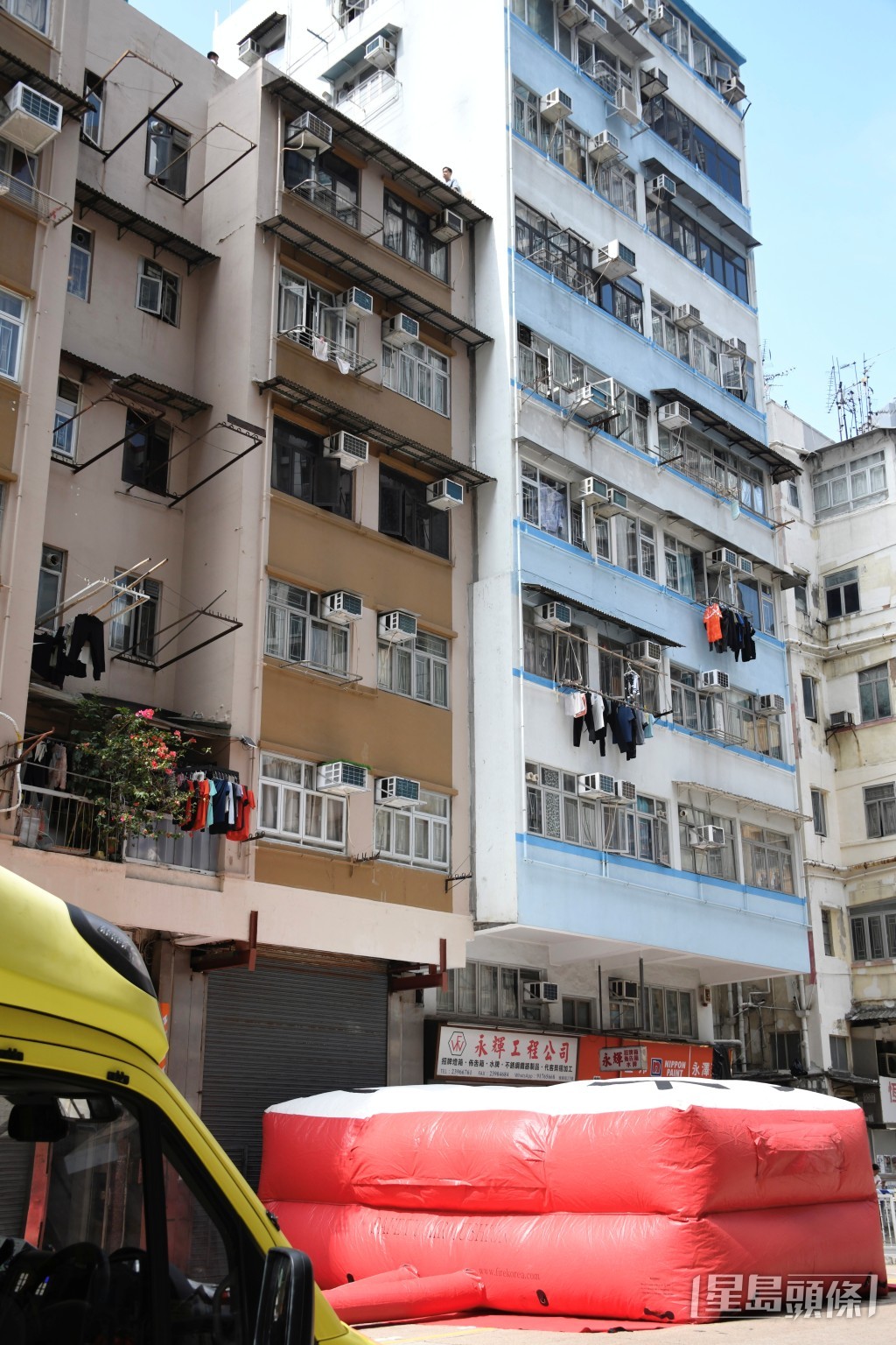 男子危坐天台,消防開氣墊戒備。楊偉亨攝 男子危坐天台,消防開氣墊戒備。楊偉亨攝