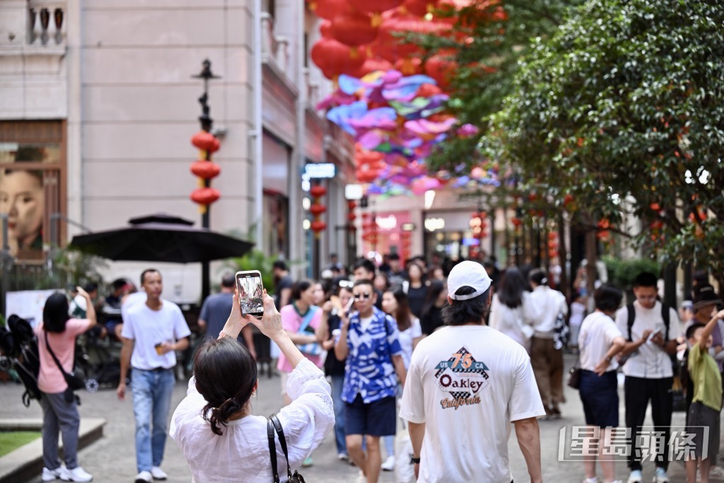 灣仔利東街掛滿國旗和中秋主題的燈飾，吸引不少人停下來拍照打卡。