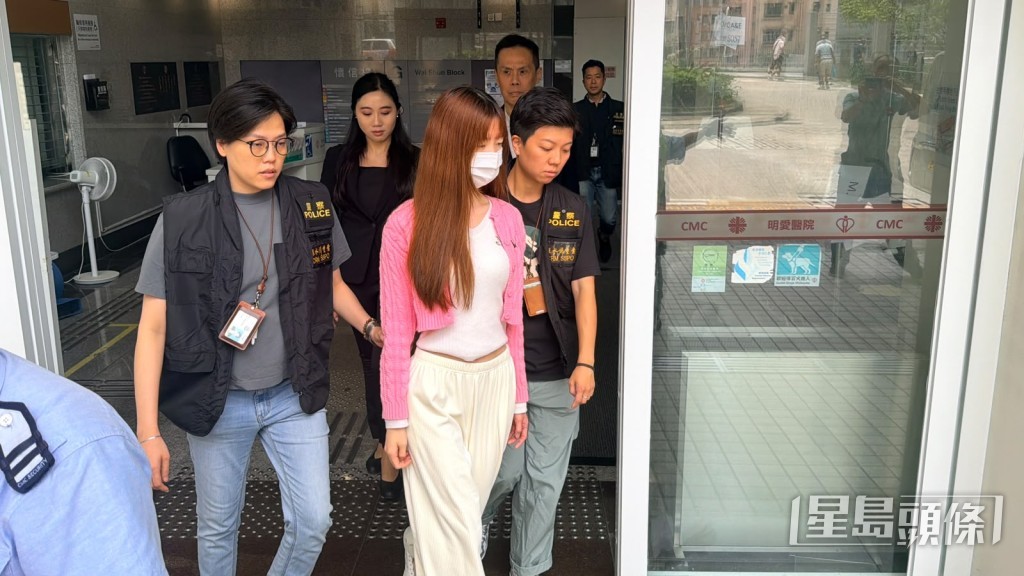 實習女醫生在明愛醫院搜證後,在探員陪同下離開醫院。梁國峰攝 實習女醫生在明愛醫院搜證後,在探員陪同下離開醫院。梁國峰攝