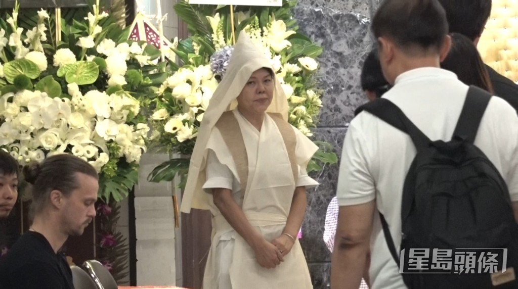 何麥遺孀 Christie 在場接待前來悼念的親友，神情憔悴。