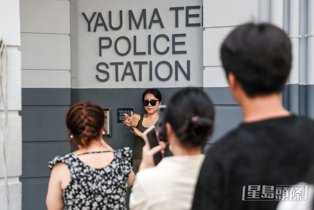 不少遊客以「持槍」手勢在「油麻地警署」招牌下拍照，扮演經典「警察」角色。
