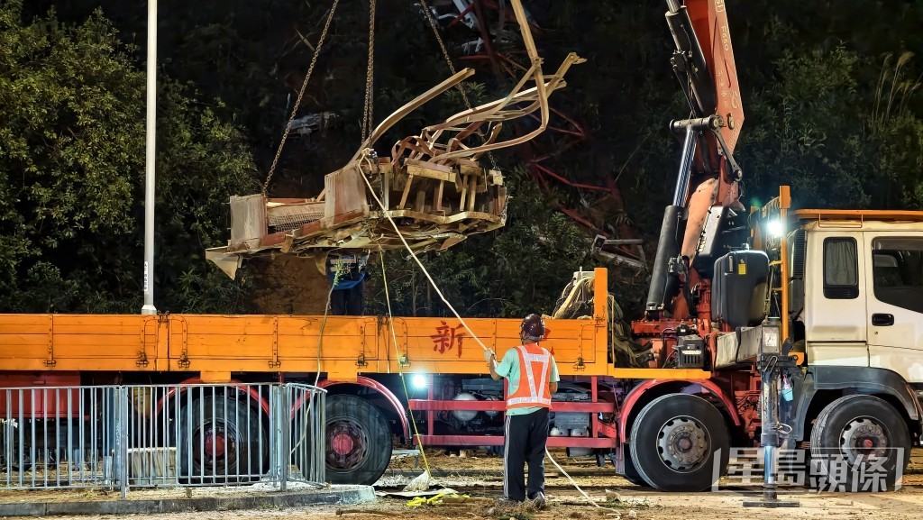 工人夜晚清理大窩口道散落的金屬殘骸。