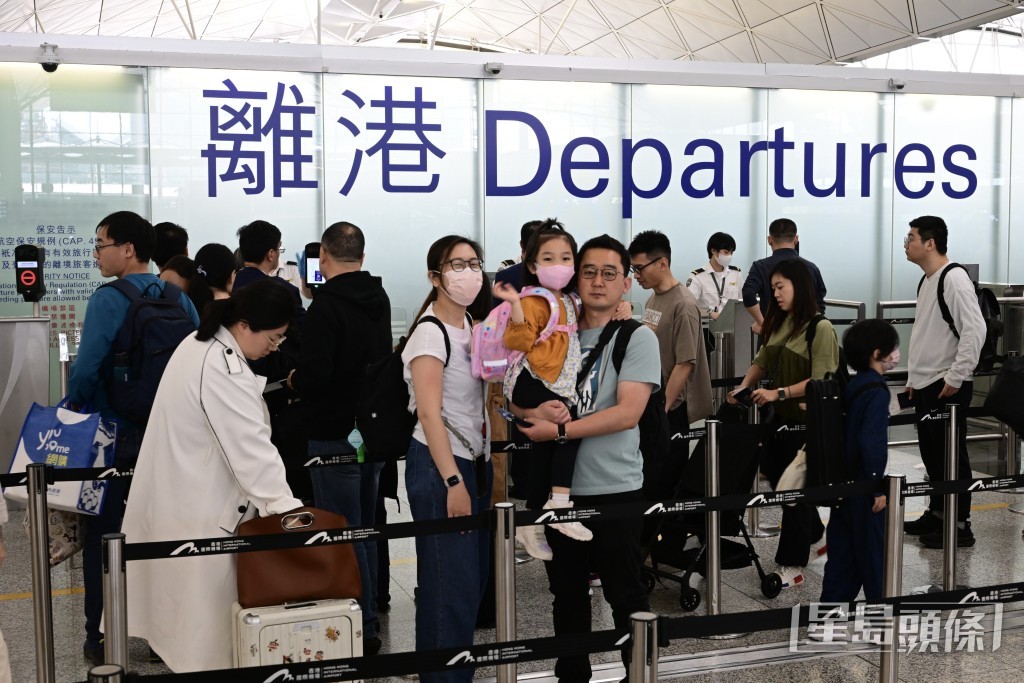 机场的登机柜台和出境位置等待人龙水泄不通。陈极彰摄