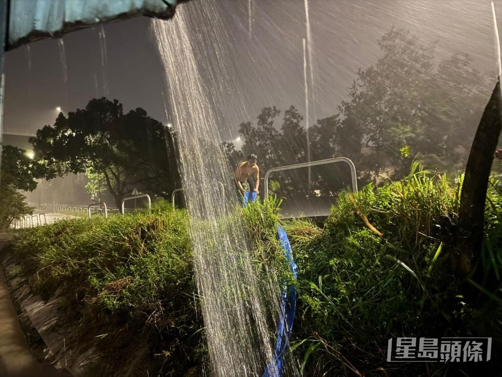 「阿棍屋」義工冒雨將水管放出馬路。 受訪者提供