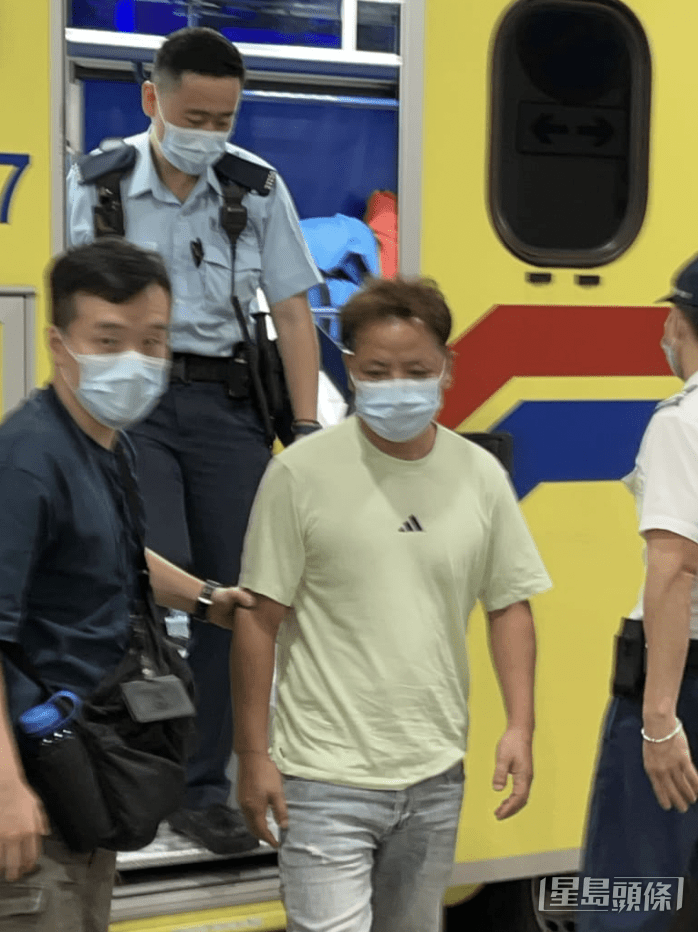 被捕男子戴上口罩，獲警員解除雙手手銬，自行步下救護車，接受治理。蔡楚輝攝