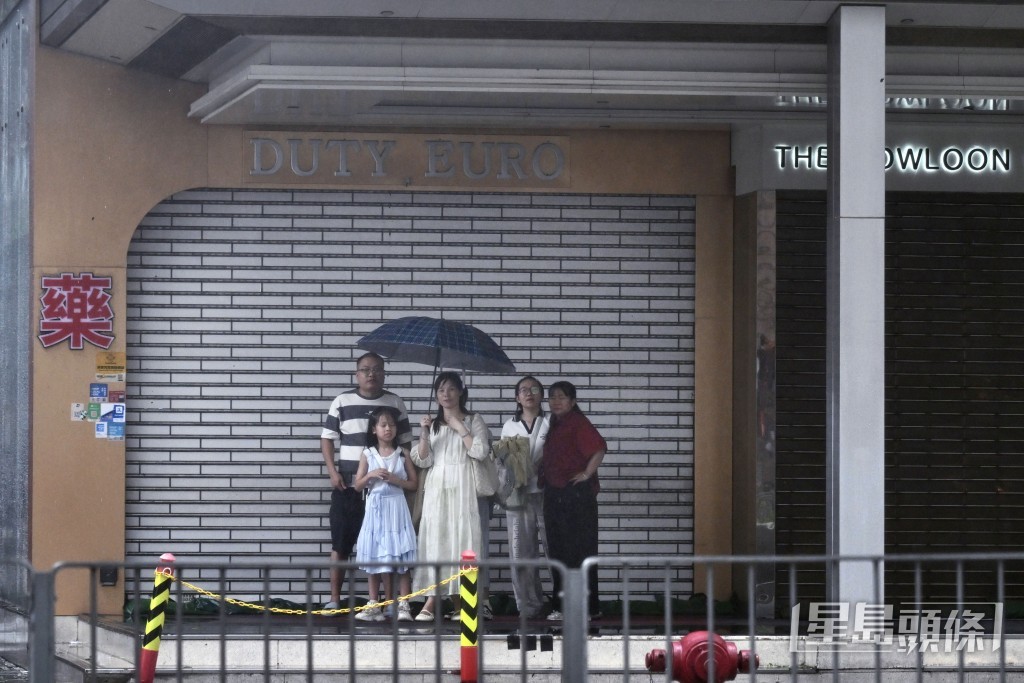 有遊客在騎樓底避雨。劉駿軒攝 有遊客在騎樓底避雨。劉駿軒攝