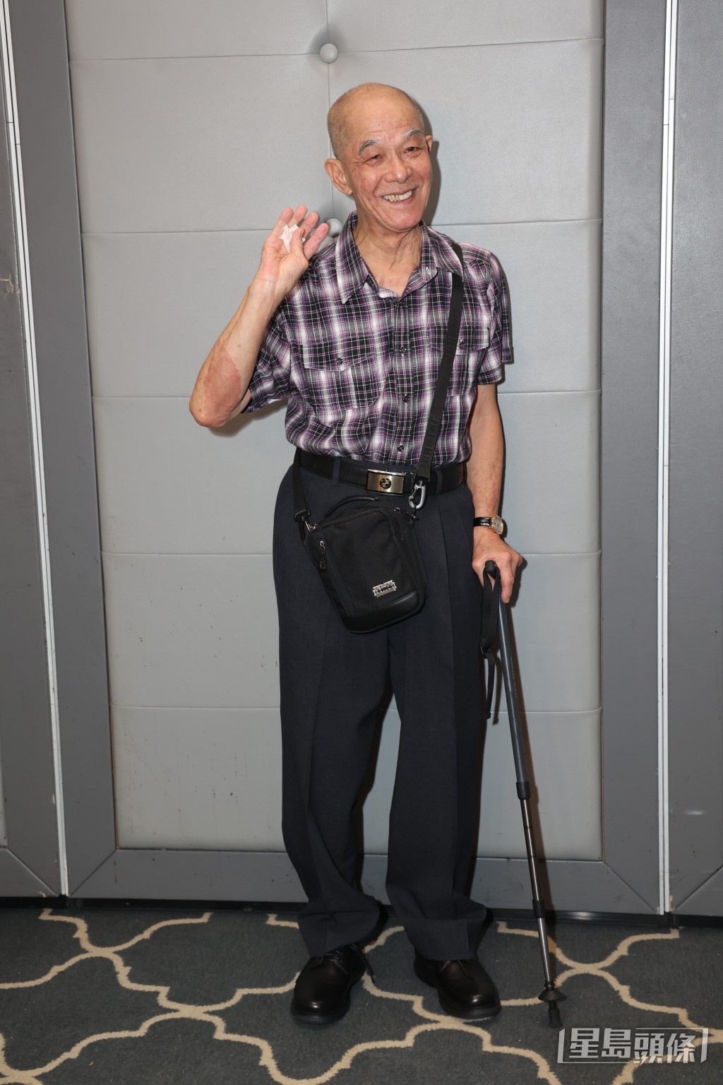 已退休的監製李添勝拄拐杖，步履蹣跚。