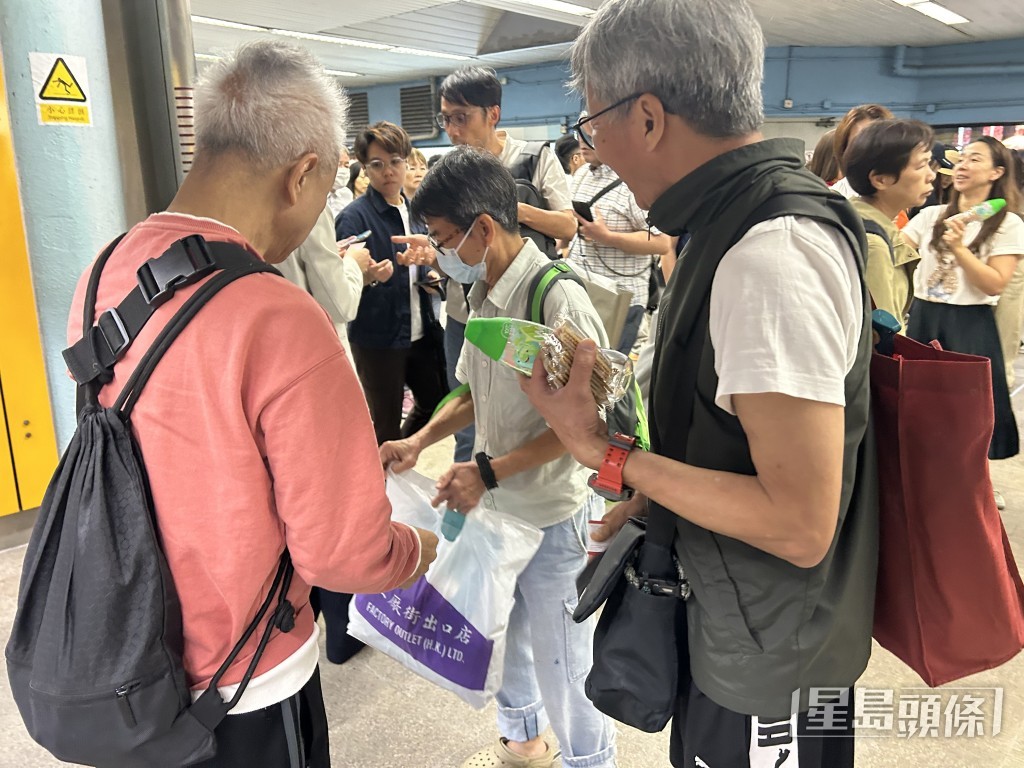 港鐵職員向受影響乘客派發食水、餅乾及免費車票。 港鐵職員向受影響乘客派發食水、餅乾及免費車票。