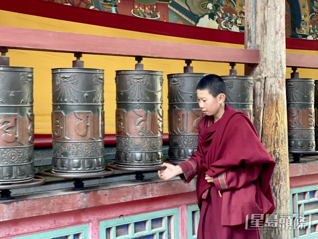  一邊轉動經輪，一邊念「六字真言」唵嘛呢叭咪吽，相當於唸誦其中所有經咒，幫助累積善業、淨化業障。