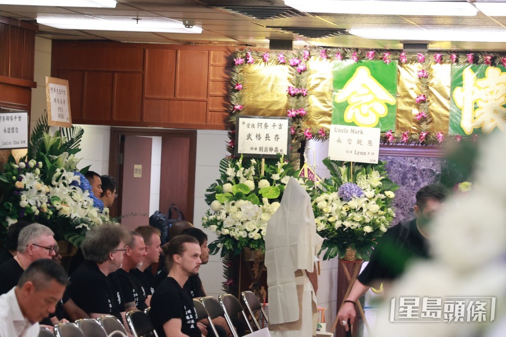 多位身穿印有「劉」字黑色T恤的同門師兄弟及外籍徒弟齊聚靈堂，送別何麥最後一程。