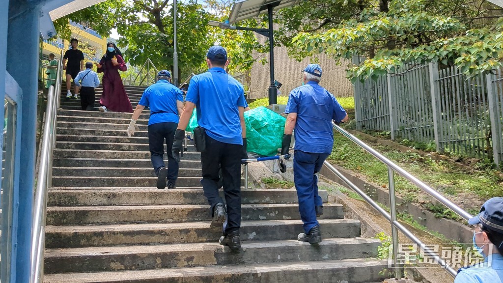 仵工移走男子遺體。 仵工移走男子遺體。