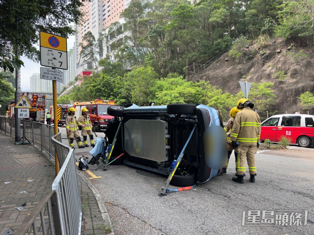 私家車翻側，消防員協助救出。