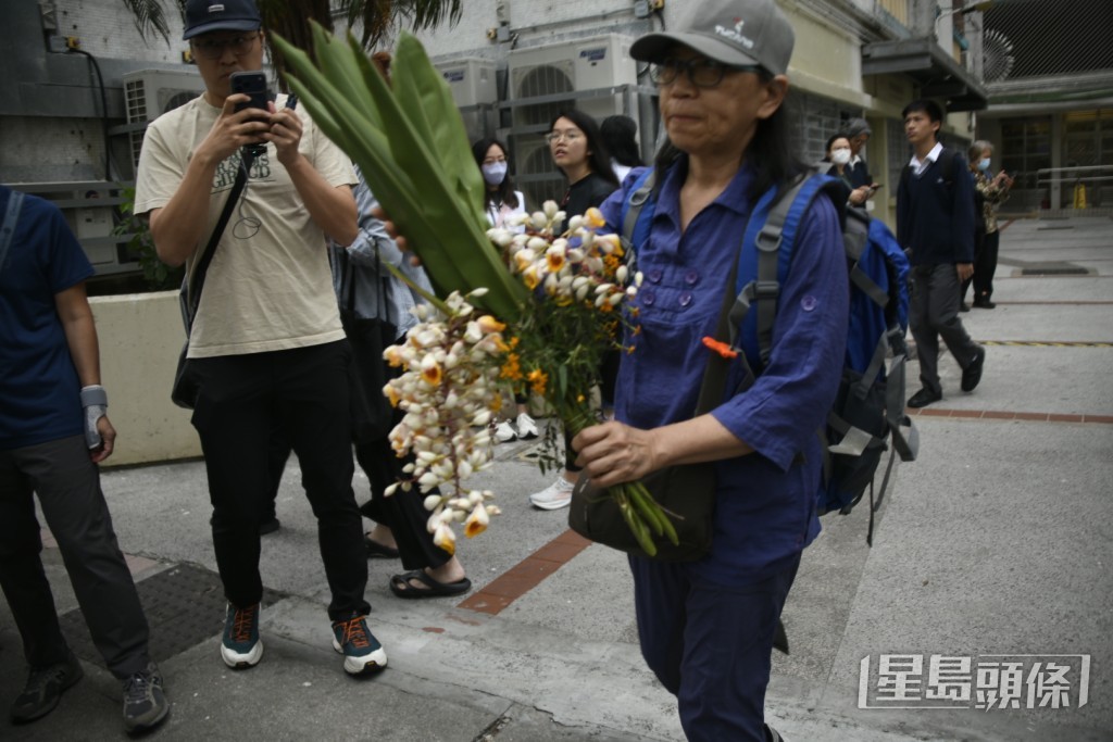 有居民帶鮮花上樓。楊偉亨攝