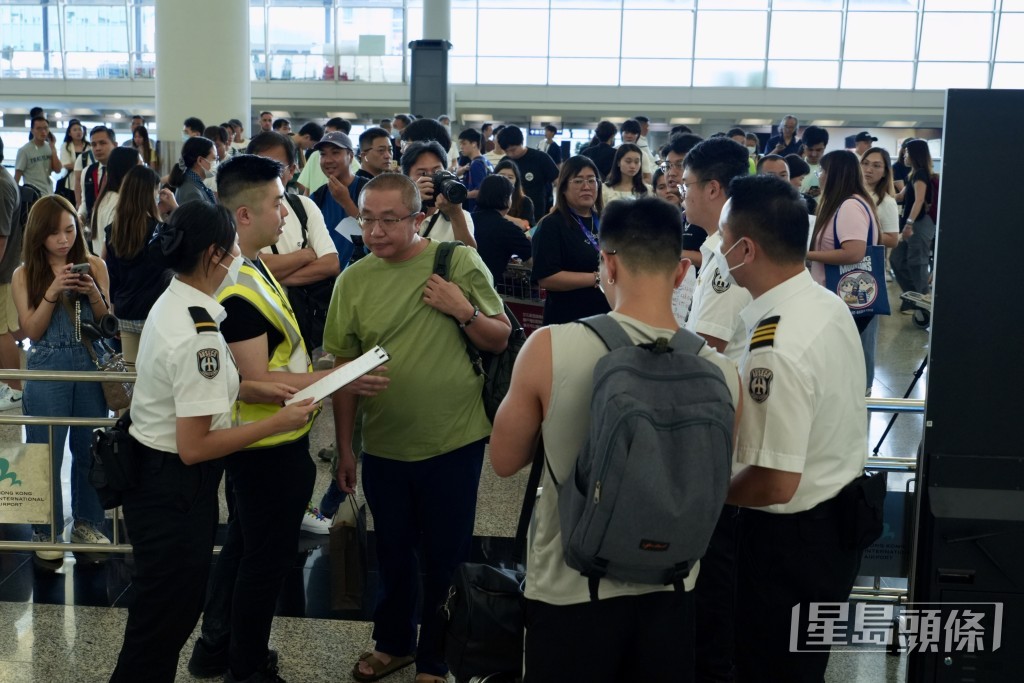 大批旅客在機場離境大堂等待。劉駿軒攝