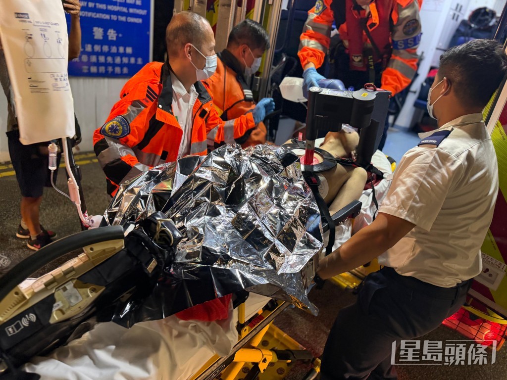 救護員為昏迷男子安上自動心外壓機，送伊利沙伯醫院搶救。曾志恆攝