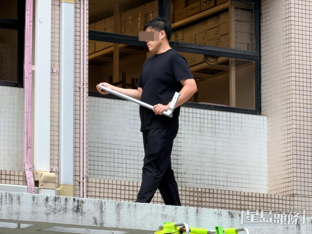 男子手持角鐵,在簷篷上來回踱步。梁國峰攝 男子手持角鐵,在簷篷上來回踱步。梁國峰攝