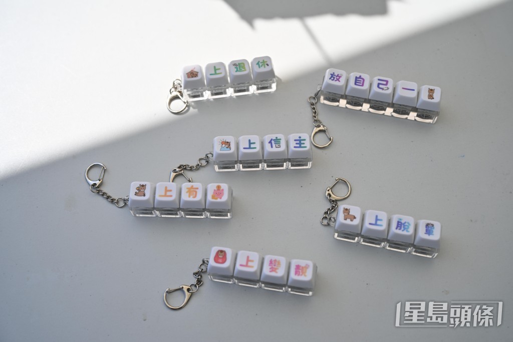 鍵盤按鈕等產品上印有幽默字句，如「放過自己一馬」、「馬上有錢」。