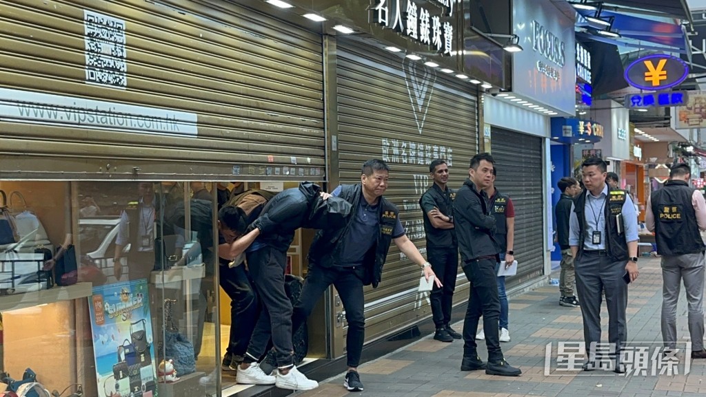 探員帶走首名疑犯。梁國峰攝 探員帶走首名疑犯。梁國峰攝