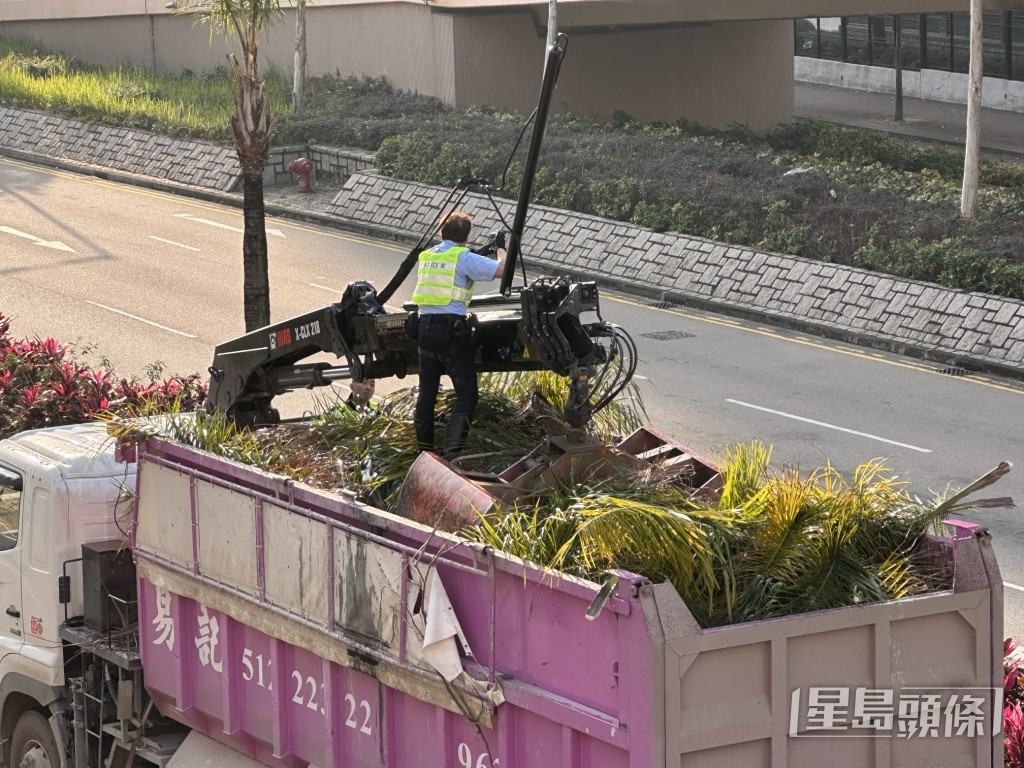 交通警爬上吊車車斗上，協助將吊臂與架空電纜分開。