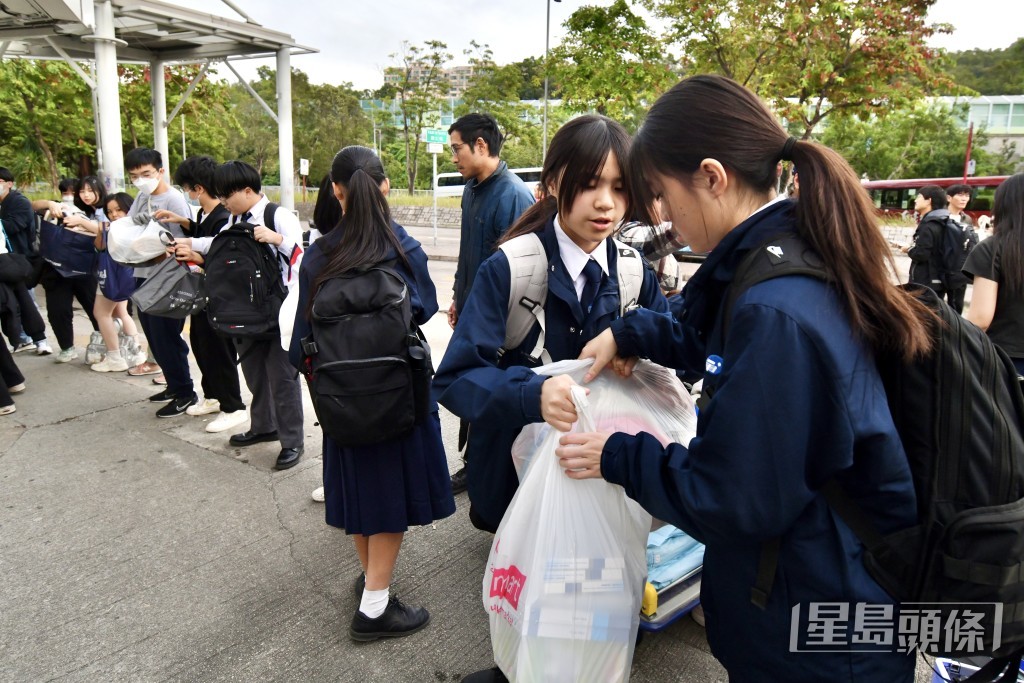 有學生揹着背囊協助搬運物資。